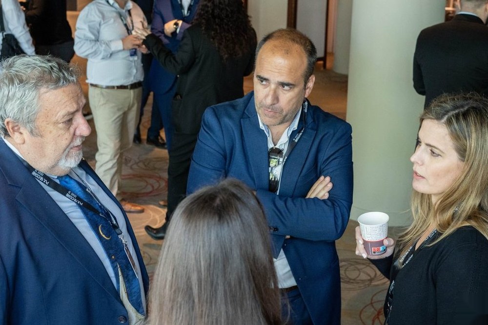Three delegates talking together during a break at a previous Excellence in Digital Banking summit