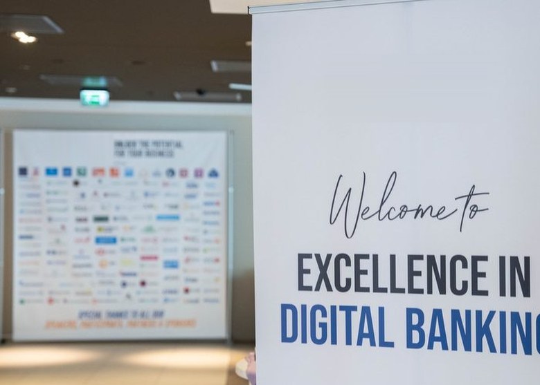 The Welcome to Excellence in Digital Banking banner in the conference room at a previous edition